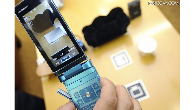 ARマーカーに携帯電話をかざすことで、画面上にオブジェクトが表示される ARマーカーに携帯電話をかざすことで、画面上にオブジェクトが表示される